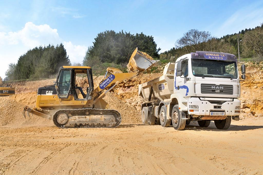 serrand-tp - un engin de chantier chargeant un camion benne de pierres